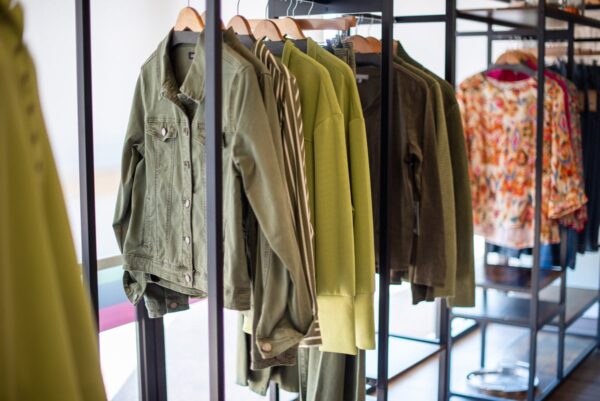 Olive green jackets and tops on a clothing rack