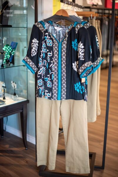 Navy floral print top with khaki pants on a display stand
