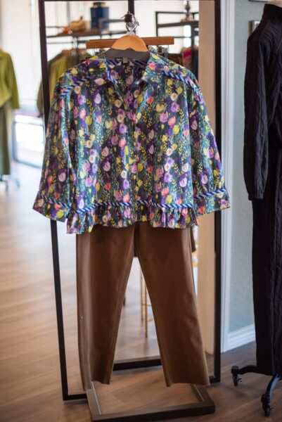 Printed blouse with brown pants on a display stand