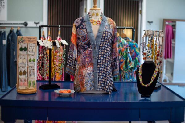 Printed outfit on a mannequin beside a handbag display