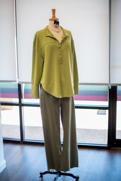 Lime green tunic with olive pants on a mannequin